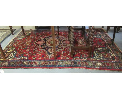 Middle Eastern design red ground carpet with central medallion of flower heads and having geometric boarder. (B.P. 21% + VAT)