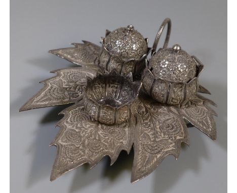 White metal novelty three piece cruet set, the base in the form of a leaf with floral and other decoration. (B.P. 21% + VAT) 