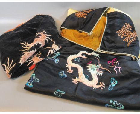 Two oriental probably Chinese velvet and embroidered cushion covers with dragon chasing flaming pearl design, together with a