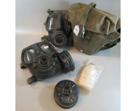 Two vintage military gas masks, one contained in a military canvas satchel. (B.P. 21% + VAT)
