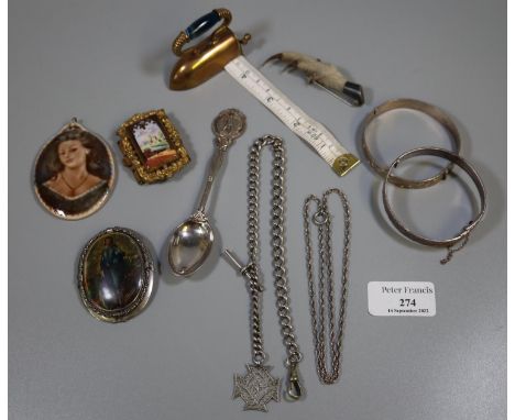 Collection of assorted metalware items; brass flat iron shaped tape measure, pin brooches, porcelain portrait pendant, grouse
