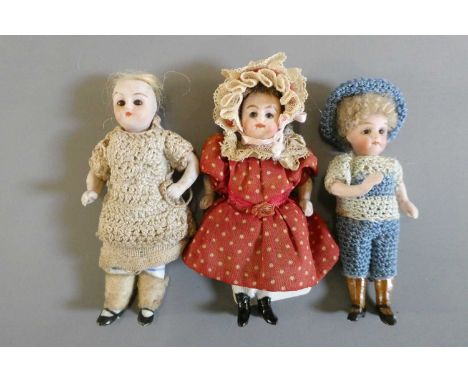 Three all bisque doll's house dolls, all with jointed shoulders and hips, brown glass fixed eyes, painted features, and mould