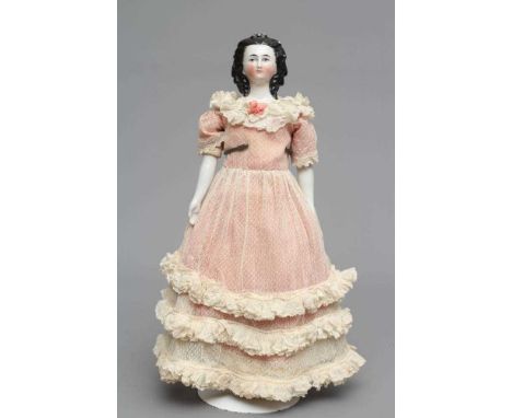 A Victorian china shoulder head doll, with painted face, moulded netted hair, fabric body, china lower limbs and pink dress, 
