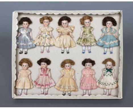 A boxed set of ten all bisque miniature dolls, all with blue glass fixed eyes, jointed necks, shoulders and hips, straight le