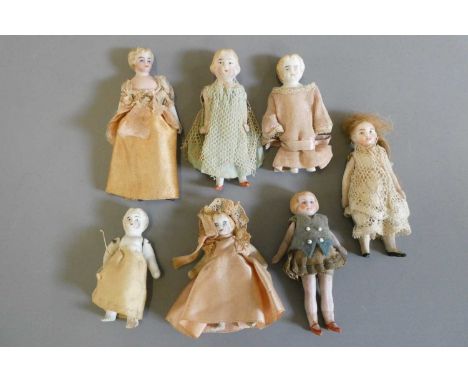 Seven doll's house dolls, comprising six all bisque dolls with painted features and jointed shoulders, one with fixed legs th