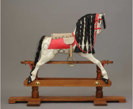 A vintage wood carved rocking horse, with dappled grey paintwork, amber glass eyes, hair mane and tail, on wooden and metal s