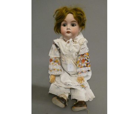 A Gebruder Kuhnlenz bisque socket head doll, with brown glass fixed eyes, open mouth, teeth, wood and composition jointed bod