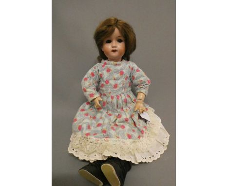 A W. Goebel bisque socket head doll, with brown glass eyes, open mouth, teeth, wood and composition jointed body and floral d