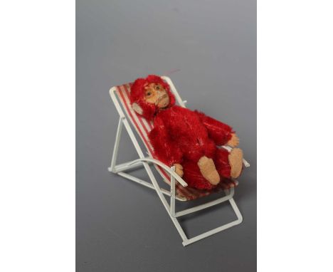 A rare Schuco red monkey compact, with felt hands and feet, powder puff and associated deckchair, monkey 3 1/2" long (Est. pl