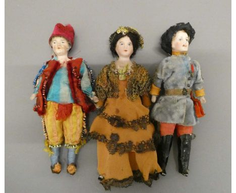 Three bisque shoulder head doll's house dolls, comprising two gentlemen and a lady, all with moulded hair, painted features a