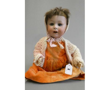 A Jutta bisque socket head doll with blue glass sleeping eyes, open mouth, applied teeth, bent limb composition body and oran