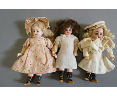 Three bisque socket head doll's house dolls, including a Kammer &amp; Reinhardt, all with blue glass sleeping eyes, compositi
