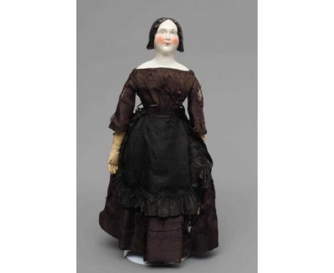 A Victorian china shoulder head doll, with painted face, well moulded hair, fabric body, kid lower arms and black dress, 17" 