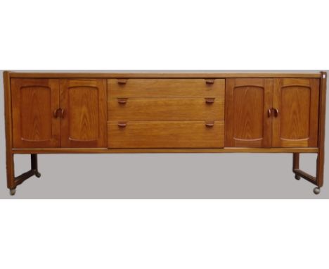 Mid Century Furniture - A Nathan teak sideboard with three graduated drawers flanked by two pairs of cupboard doors on castor