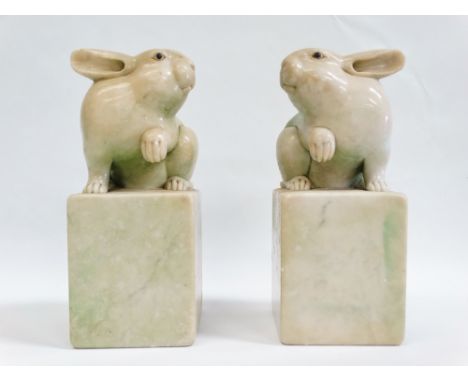 Chinese Scroll Weights - A pair of 19th century opposing carved green flecked hardstone rabbits sejant with one raised paw on