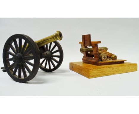 Scale Canons - A turned brass field canon, height 8.9cm, together with a ship's canon and a wooden gun port, mounted on an oa