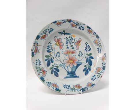 18th Century Faience - A polychromed tin glazed ceramic charger with flower detail and foliage, diameter 33.9cm. 