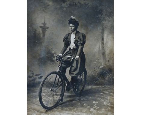 Cycling - A circa 1900 black and white silvered photograph of a lady wearing cycling pantaloons in a naturalised setting, 28.