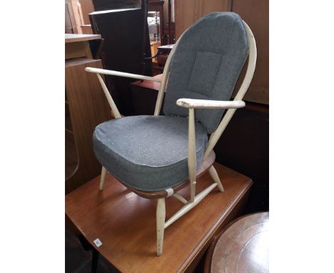 An Ercol low spindle back armchair (one spindle missing) 
