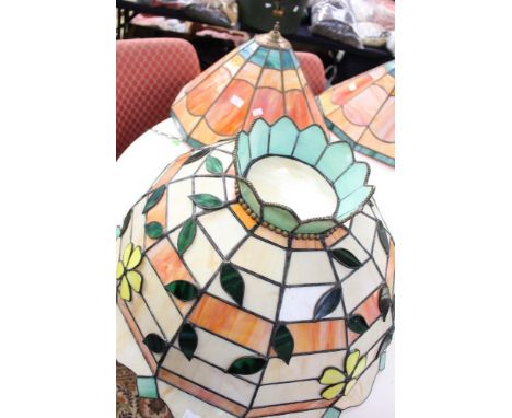 A large Tiffany style pendant, lamp shade in orange and cream with flower detail; together with similar in orange and green 