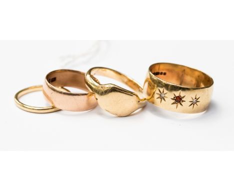 A group of four gold rings, comprising an 18ct gold band, a 9ct gold diamond and ruby gypsy set ring, a 9ct rose gold band an