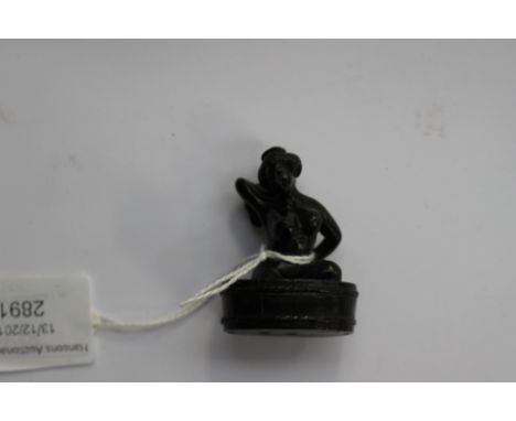 A Japanese dark wood carved Netsuke, depicting an Oriental woman bathing, signed to the base 