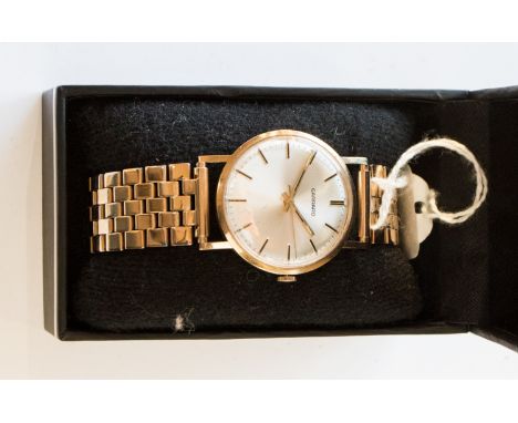 A 9ct gold Garrard wristwatch with batons and champagne dial, on a plated brick link bracelet strap