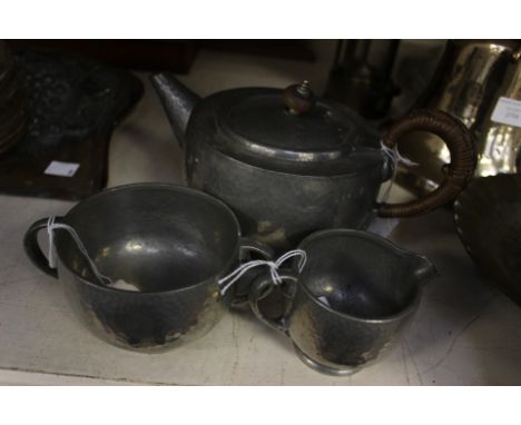 A Tudric pewter tea service, comprising teapot, sugar and milk, stamped Tudric 01216 to base (3) 