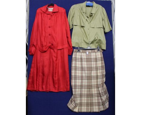 A red silk shirt waisted dress (late 1950s) with a belt and kick pleats made by John Comey, a blue/green check jacket edged i