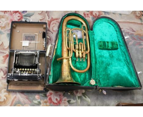 A brass instrument in case and Corona typewriter 