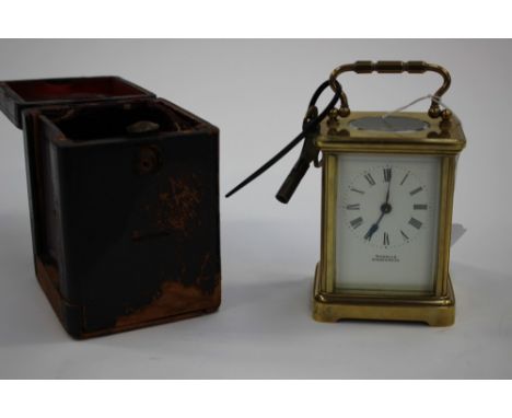 A brass carriage clock, marked Nicholls Windermere, in original case with key