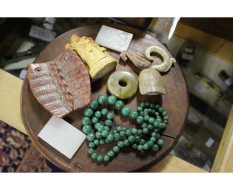 A collection of carved curios to include fossil style, escutcheons 'Walsingham' burial type figures and 'Jade Spinach' type g