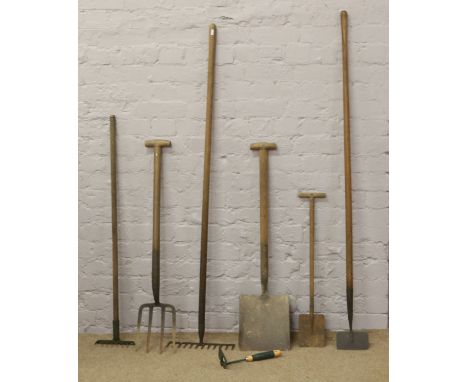 A quantity of gardening tools including rakes, spade, fork etc.