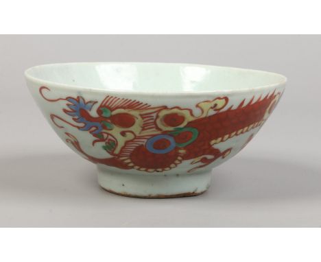 A 17th / 18th century oriental provincial bowl, possibly Korean or Chinese painted in coloured enamels with a dragon chasing 