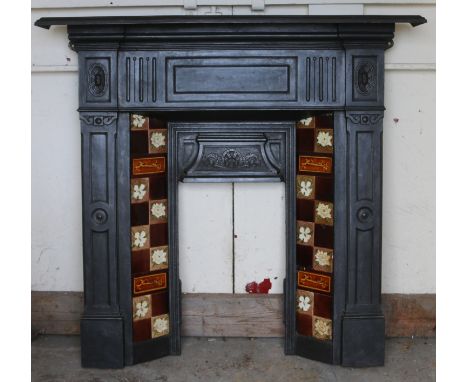 A cast iron fire surround with floral Majolica tile decoration.