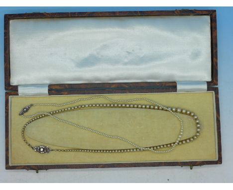 A string of simulated pearls with silver clasp and a string of seed pearls with silver and marcasite clasp, one boxed