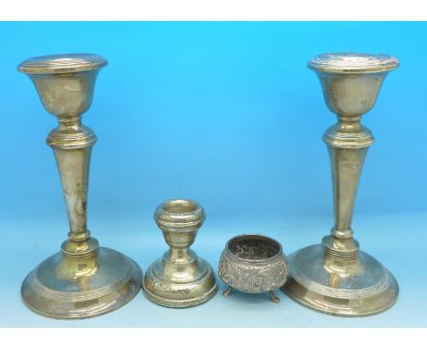 A pair of silver candlesticks, one other silver candlestick and a white metal salt, one of pair a/f, pair 16.5cm