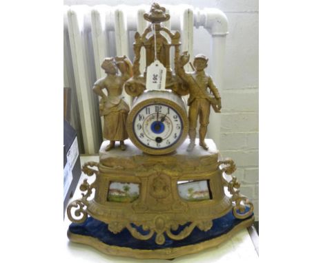 A FRENCH FIN DE SIECLE SPELTER GILT MANTLE CLOCK INSET WITH PAINTED PORCELAIN PLAQUES, ON GILTWOOD PLINTH