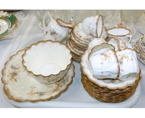 A Royal Doulton Burslem bone china tea service with powder gilt borders and floral spray decoration