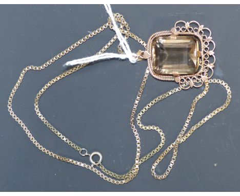 A yellow metal pendant set with a rectangular cushion cut smoky quartz in rope twist and pierced filigree frame, unmarked, on