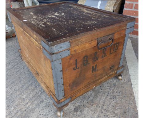 A metal bound stained wood travelling trunk on castors