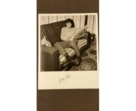 GEORGE BEST, signed 8 x 10 b/w photo showing him relaxing on sofa with newspaper, signed to lower white border, EX