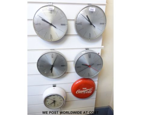 Four 'slave' dial clocks together with an Astral electric clock and a Coca Cola advertising clock