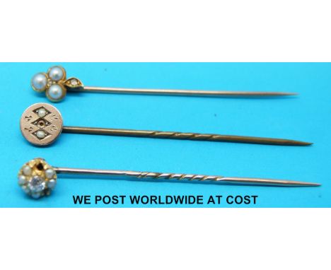 Three yellow metal stick pins set with seed pearls and diamonds 