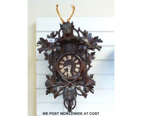 A c1930 Black Forest cuckoo clock with carved stag, oak leaves and crossed rifles