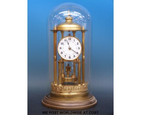 A late 19th / early 20thC anniversary clock with disc style pendulum, decorated enamel dial and steel spade hands, under glas