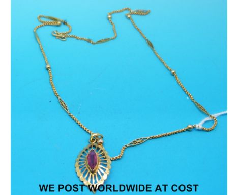 A yellow metal necklace with sphere and diamond decoration and pendant set with a ruby (7.9g)