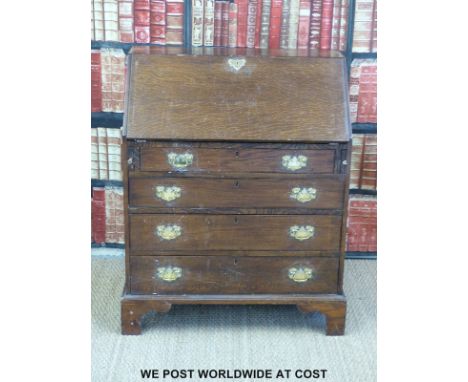 A Georgian oak bureau with fitted interior and four graduated drawers raised on bracket feet (width 82cm, depth 48cm, height 
