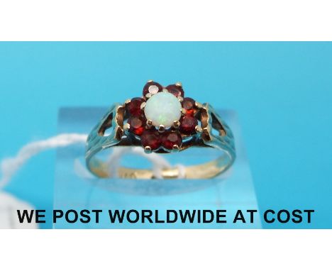 A 9ct gold ring set with an opal surrounded by garnets (size P)