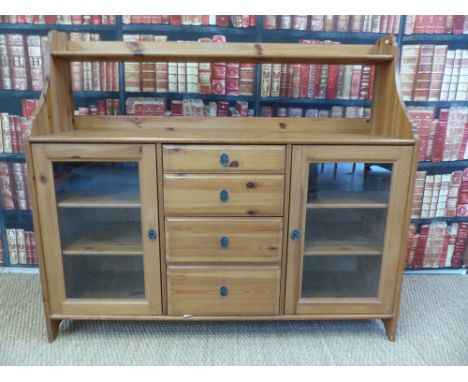 A pine sideboard with shelf above and four central drawers flanked by cupboards (width 141cm, depth 42cm, height 122cm)